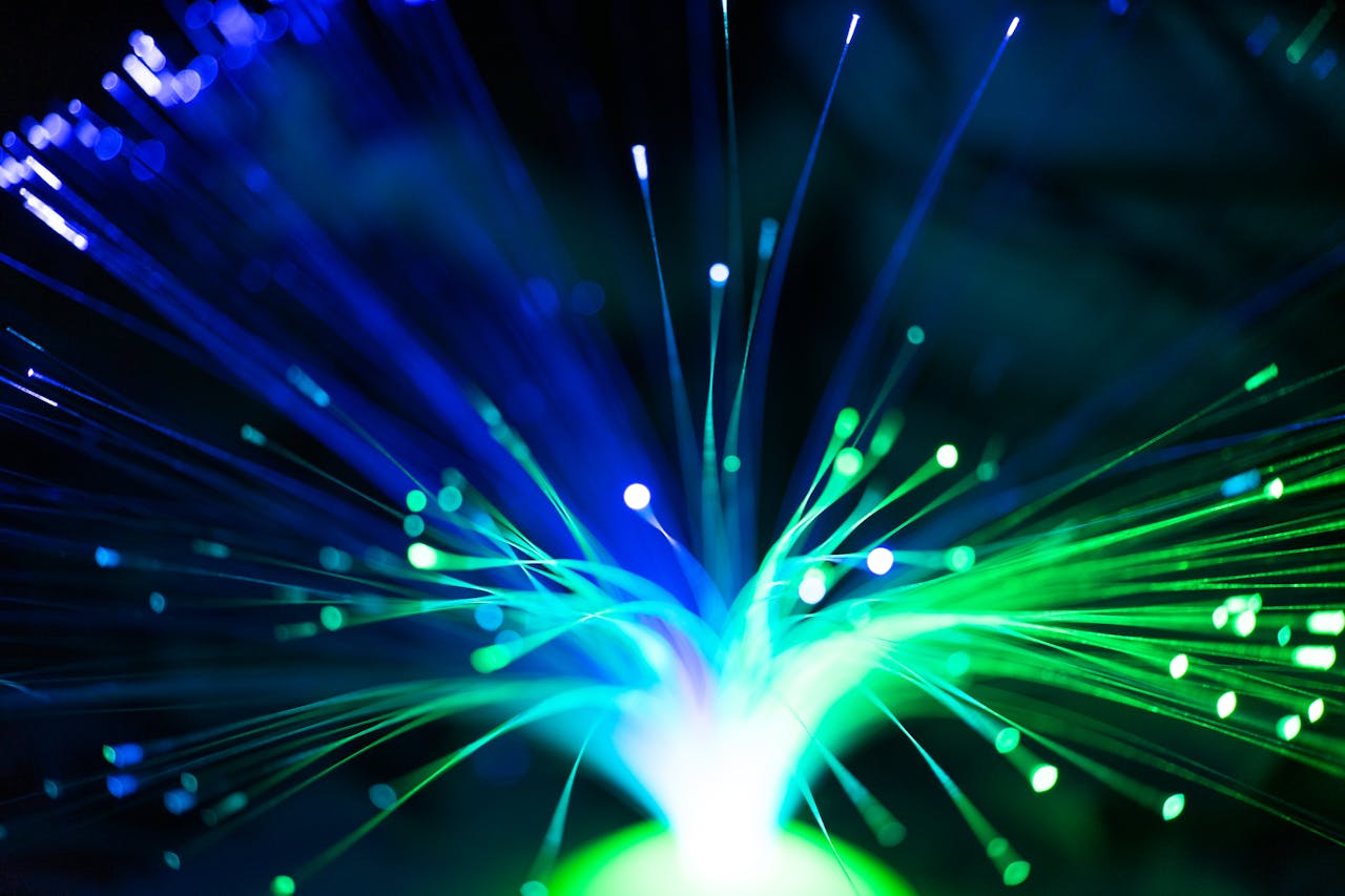 Close-up of illuminated fiber optic lights in blue and green colors, showcasing modern technology.